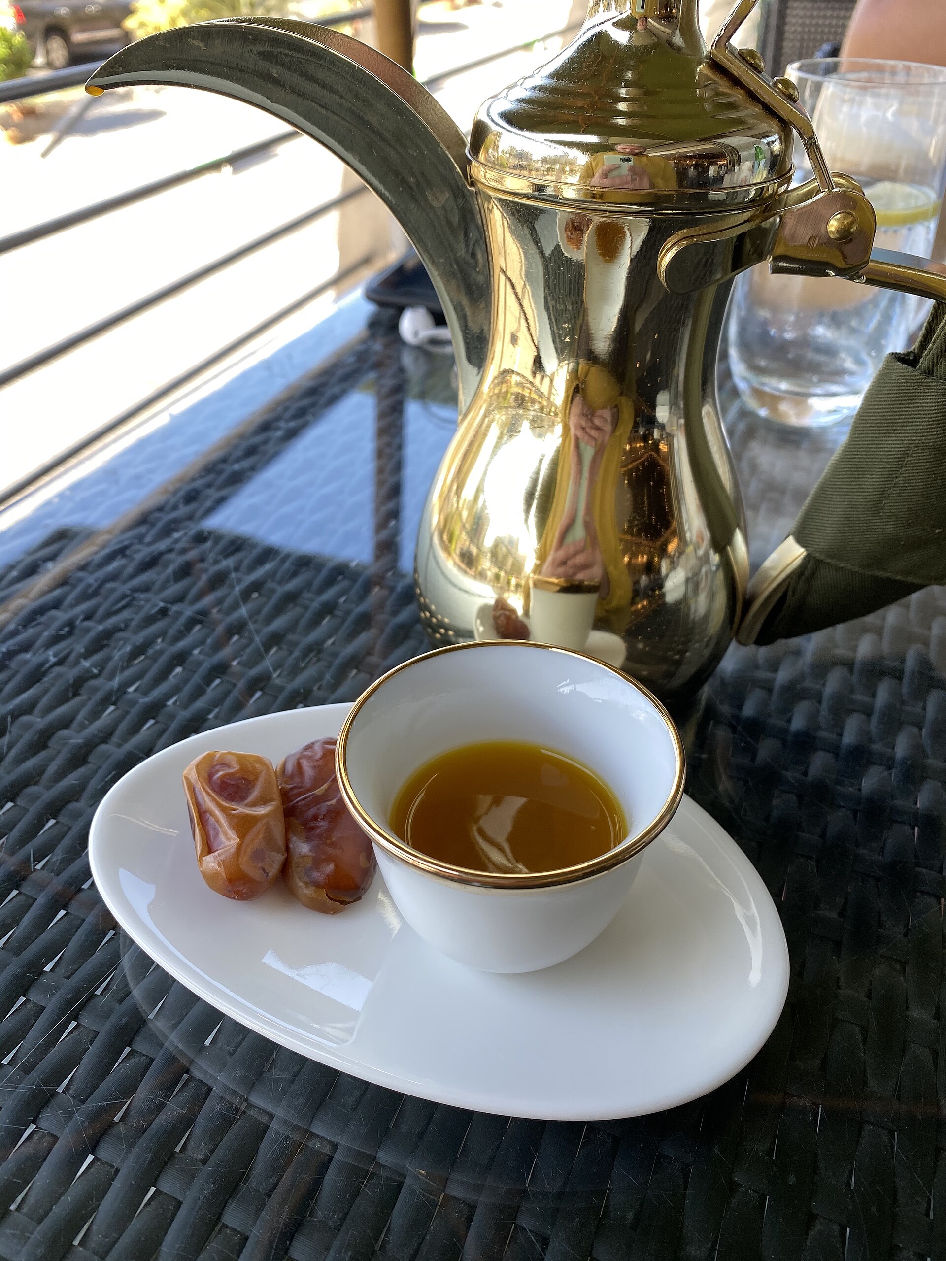 Arabic coffee with saffron, two dates and a dallah, photographed by Slywire. The source identifies this saffron serving; it is not a photograph of the Al Ameed preparation.