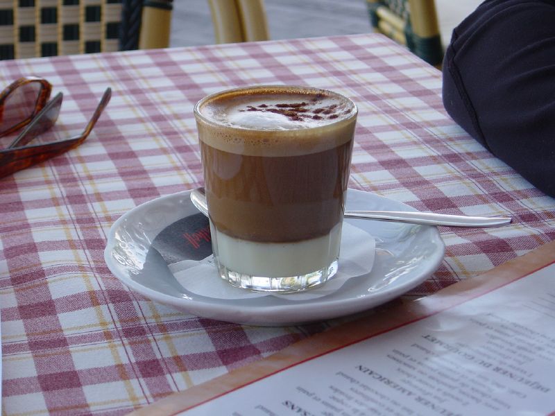 Source-identified barraquito in Tenerife. Milk and coffee layers are visible; the photograph cannot establish an alcohol quantity or this venue’s exact preparation.