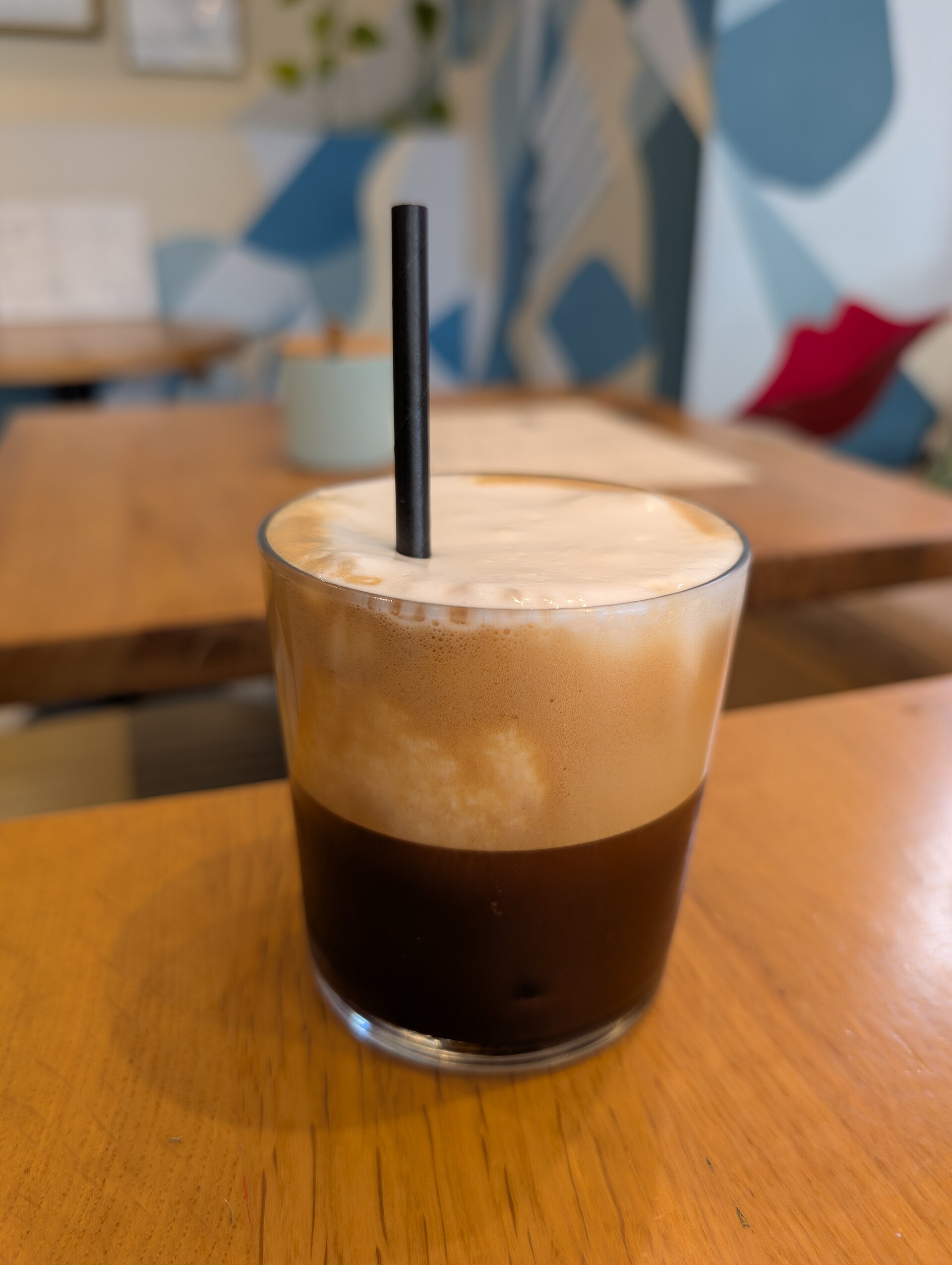 A real freddo cappuccino serving with distinct coffee and milk-foam layers. Layer height does not establish a measured milk volume.