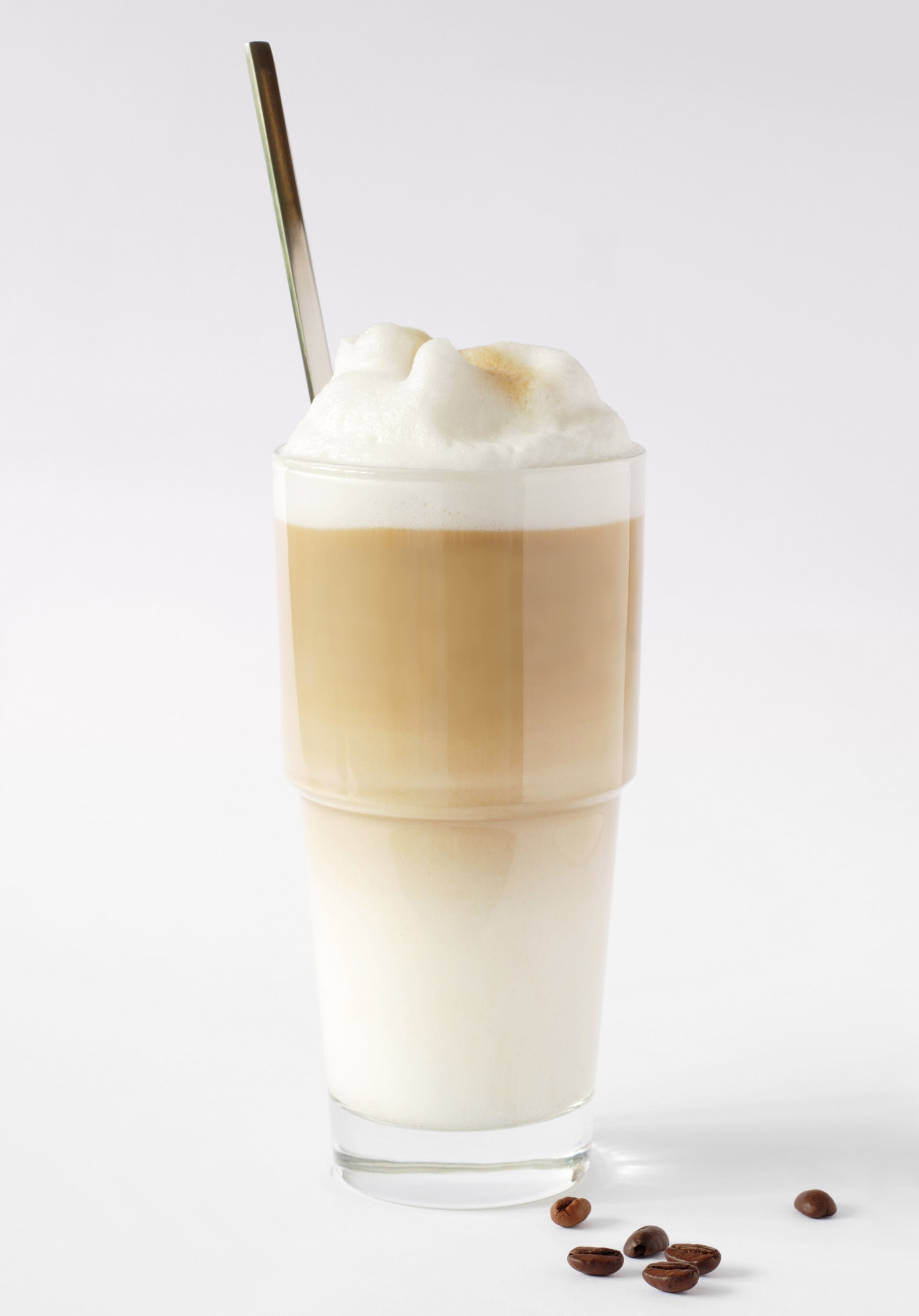 Source-identified latte macchiato with milk, coffee and foam in a tall glass. The visible layering is one presentation, not proof of the recipe quantities.