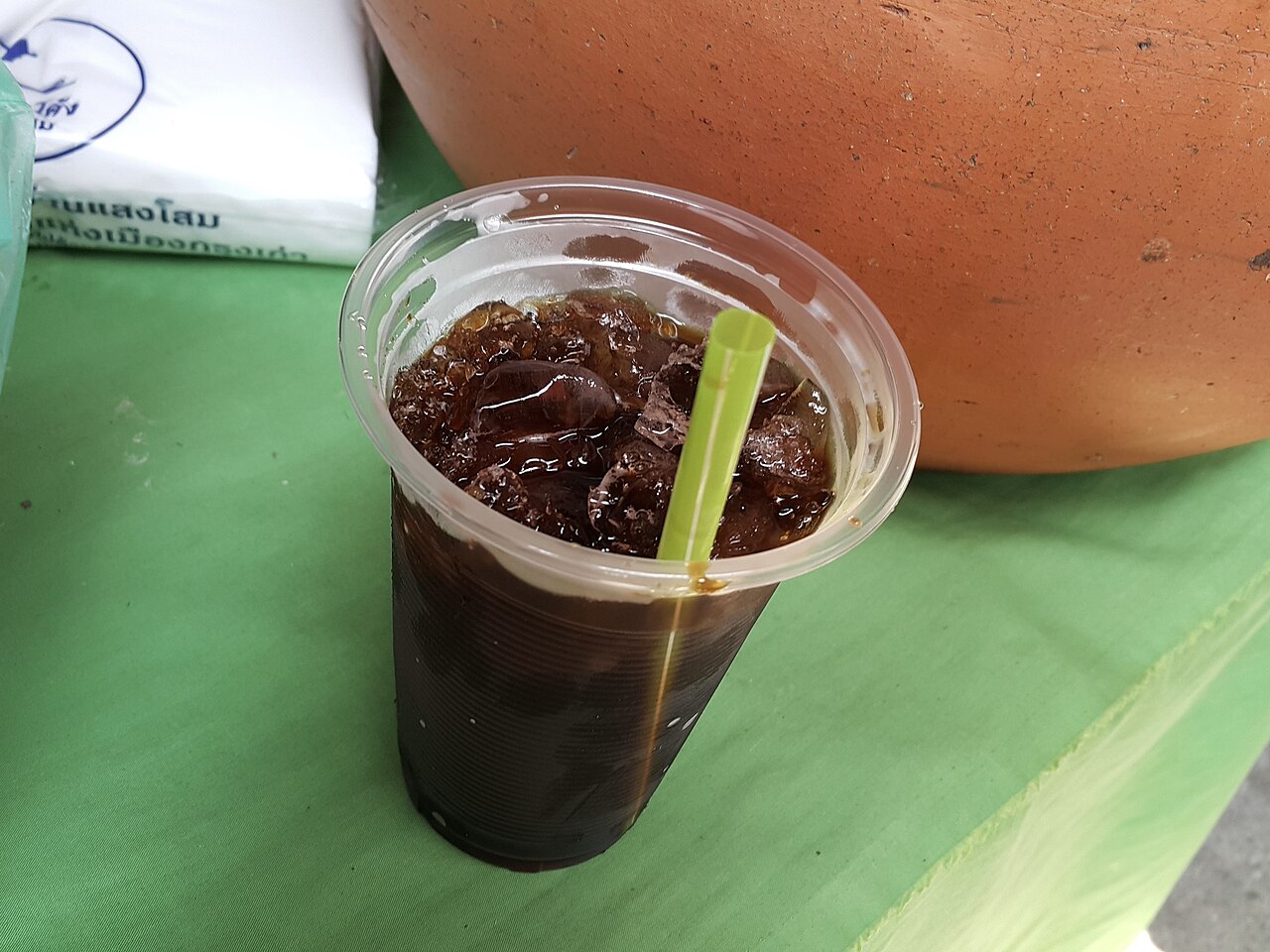 Source-identified oliang bought at an Ayutthaya market, in a takeaway cup. The photograph does not prove the named retailer’s blend or steep time.