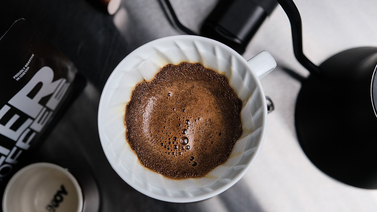 Actual V60 bloom during preparation. The starting recipe below is separately sourced; its quantities, timing and temperature are not measured from this photograph.